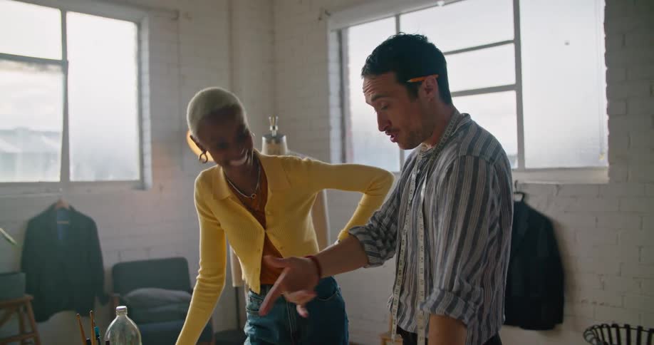 Clothing designers discuss a sketch on paper in their office