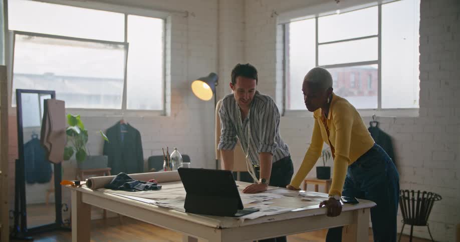 A man and a woman are discussing design in a design studio during the day