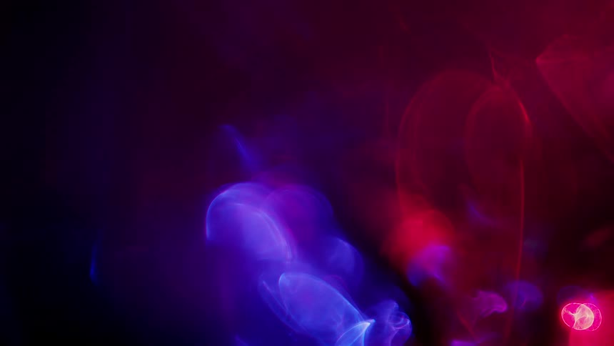 Red and blue lights glow and blur on a black background