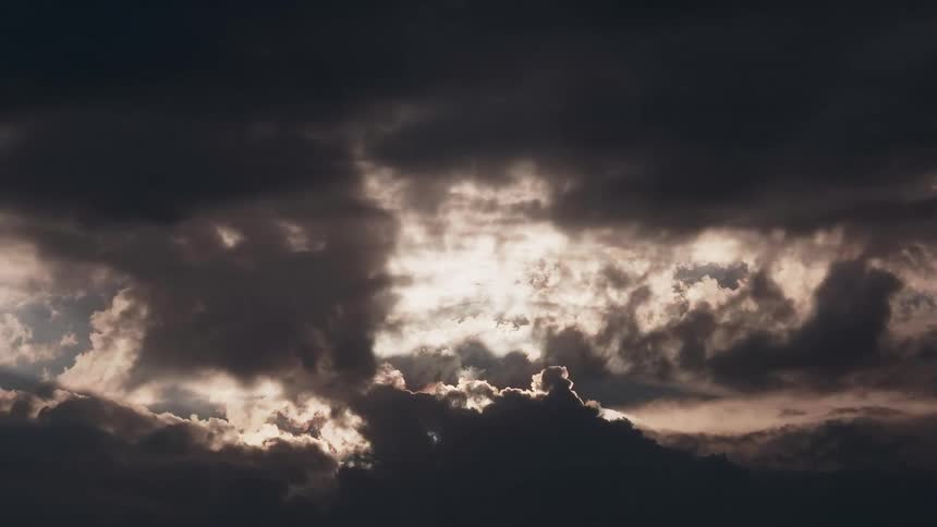 Dark clouds are illuminated by light from above