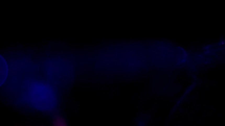 Colorful lights expand and blend and move across black