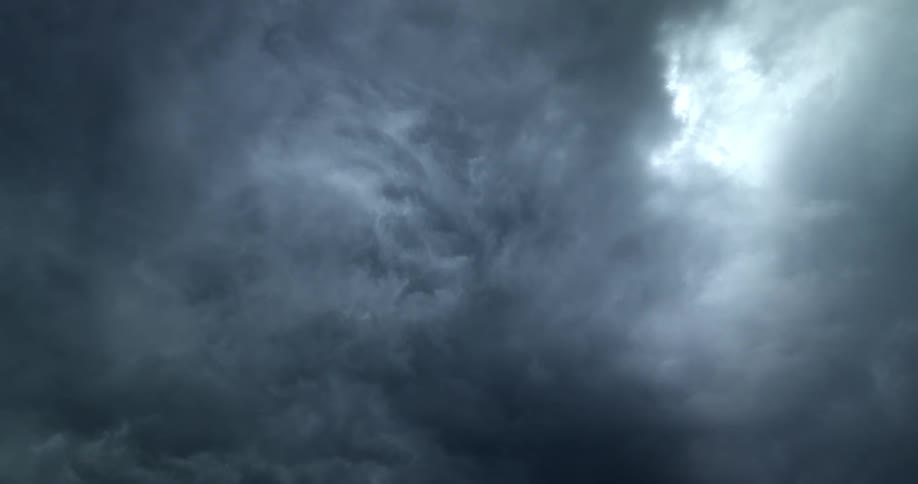Sunlight starts to peek through dark and stormy clouds