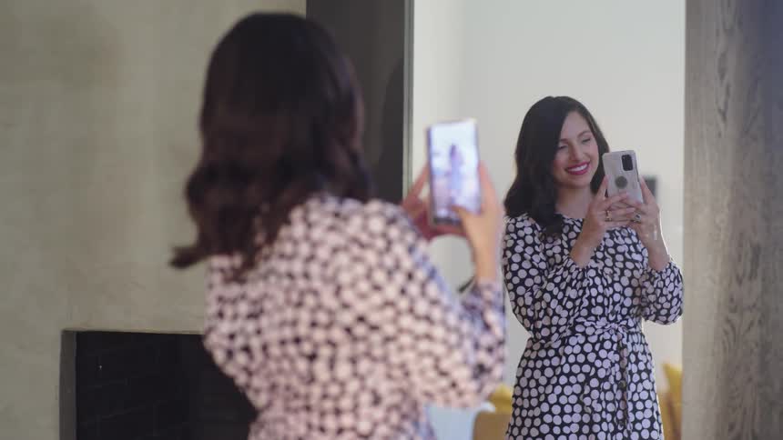 A woman is taking a selfie in front of the mirror
