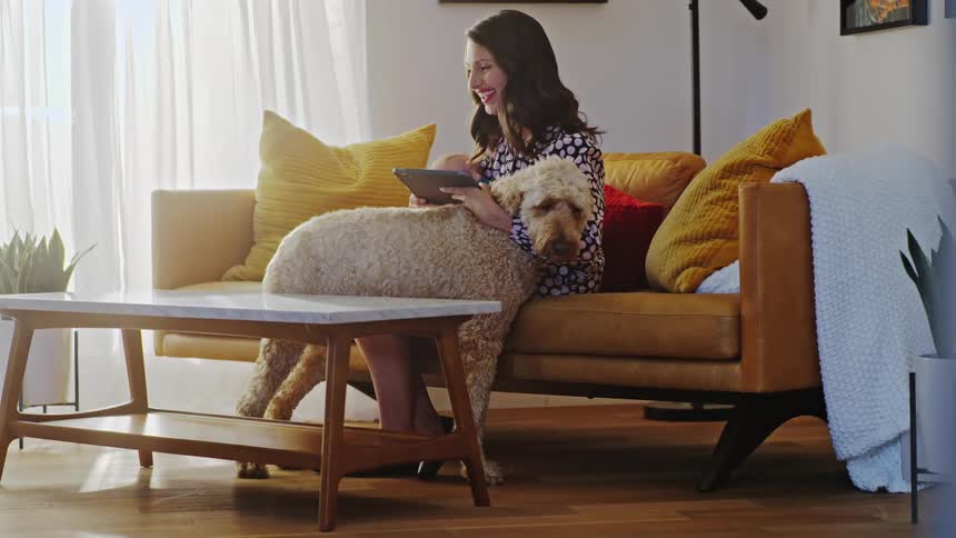 A woman sitting in a room with her dog