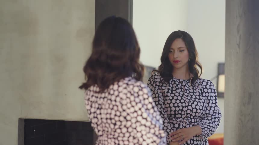 A woman trying on a dress in front of a mirror