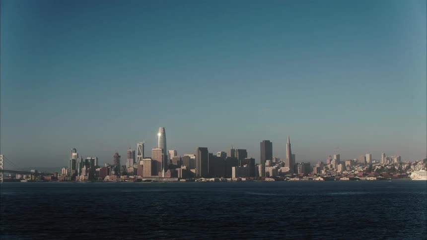 City along the coast with tall skyscrapers and towers high in the sky