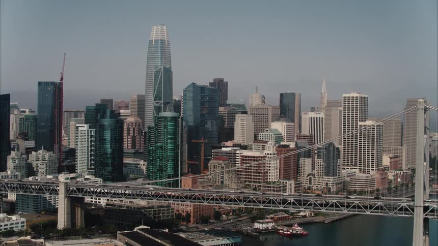 Aerial view of traffic over a bridge in front of the san francisco city skyline