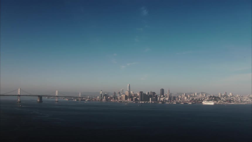 A large body of water with boats in it with a city skyline in the distance