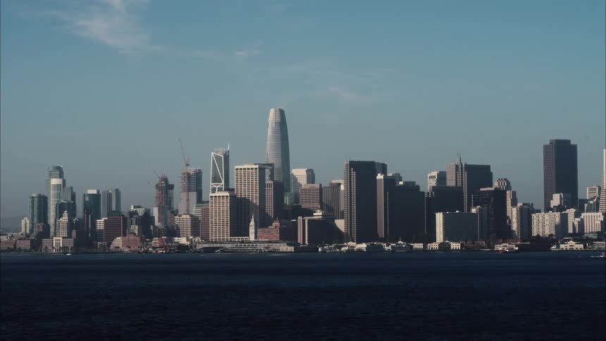 A river with a city skyline with buildings and skyscrapers with the sky and clouds in the background