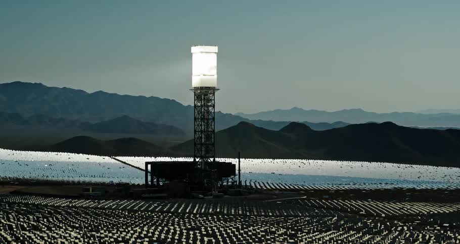 Solar panels fill a large field near a canyon