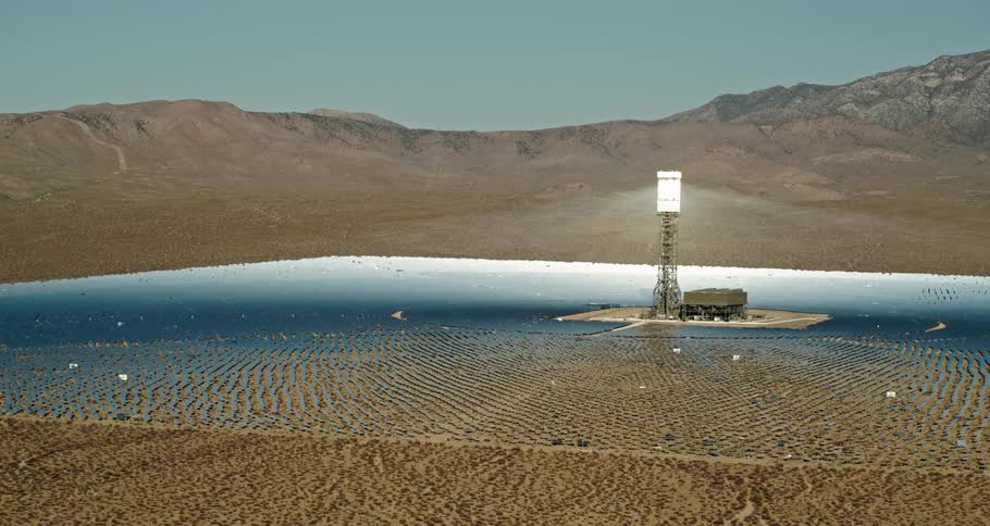 Aerial view of the tower of a solar farm receiving the sunlight reflected from the solar panels in the desert