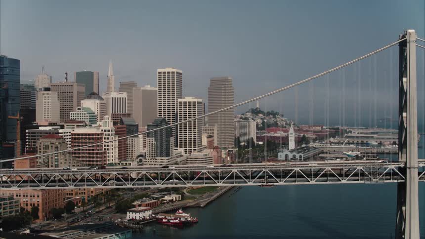 Aerial view of suspension bridge with vehicles crossing to city
