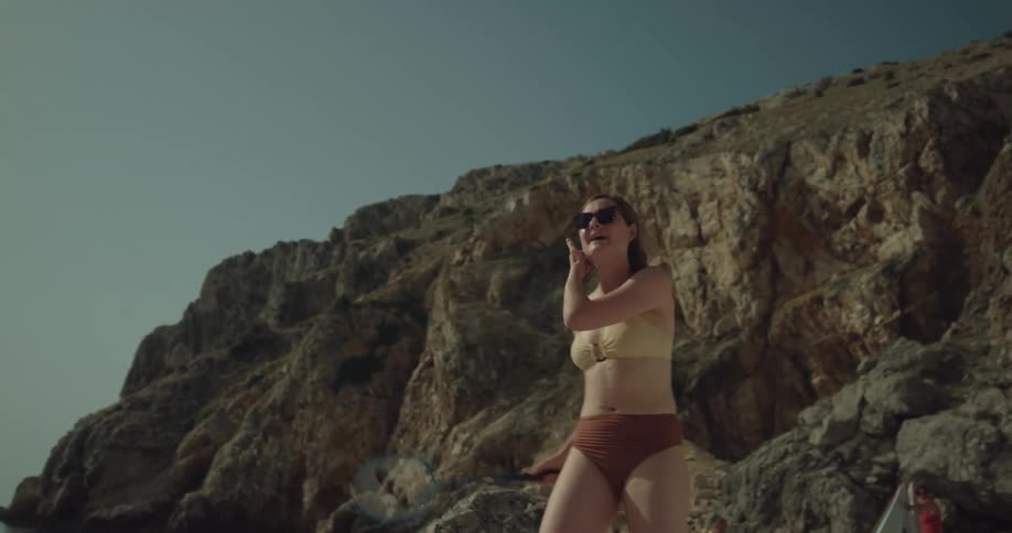 A woman is swinging a racket around on the beach