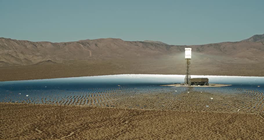 A light tower and building sit on a small island in the center of a lake