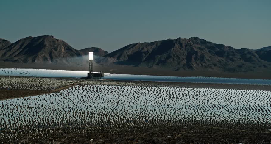 A landscape with solar reflectors a mountain range the sky and clouds in the background