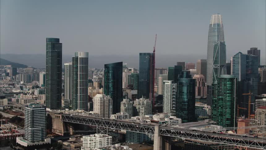 Aerial view of bridge with vehicles crossing to big city with high rise buildings