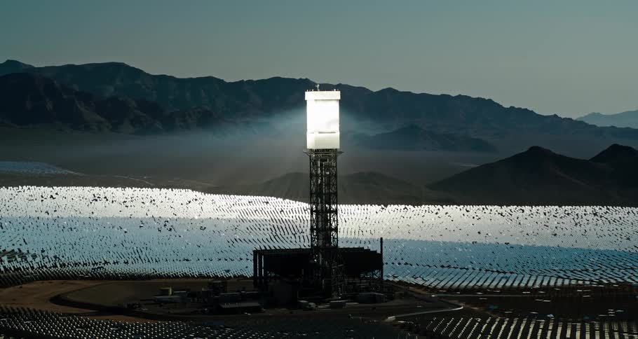 A light tower is in the middle of the solar farm