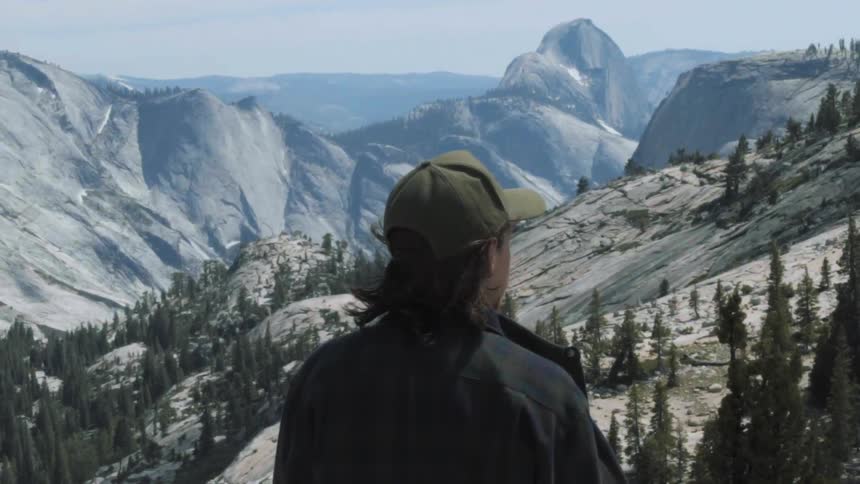 A man looks out over a mountain range from above
