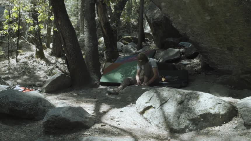 A man is camping near some large rocks