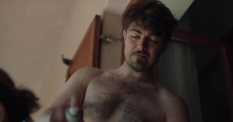 A man sprays suntan lotion on someone