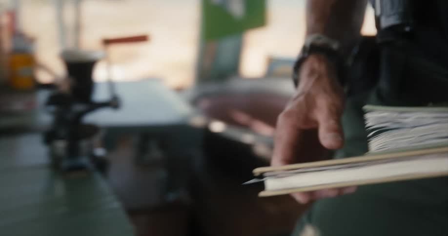 A man grabs a couple of books from the desk