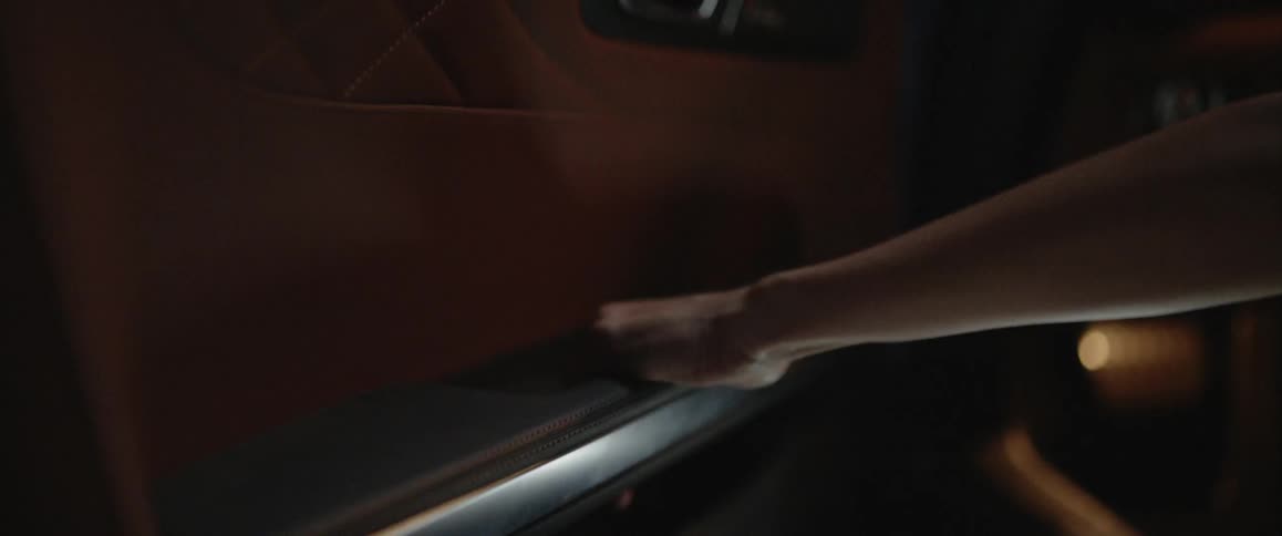 Somebodys hand reaches for a handle and opens a silver door