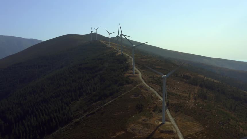 Aerial view of wind turbines spinning on the mountains in the morning