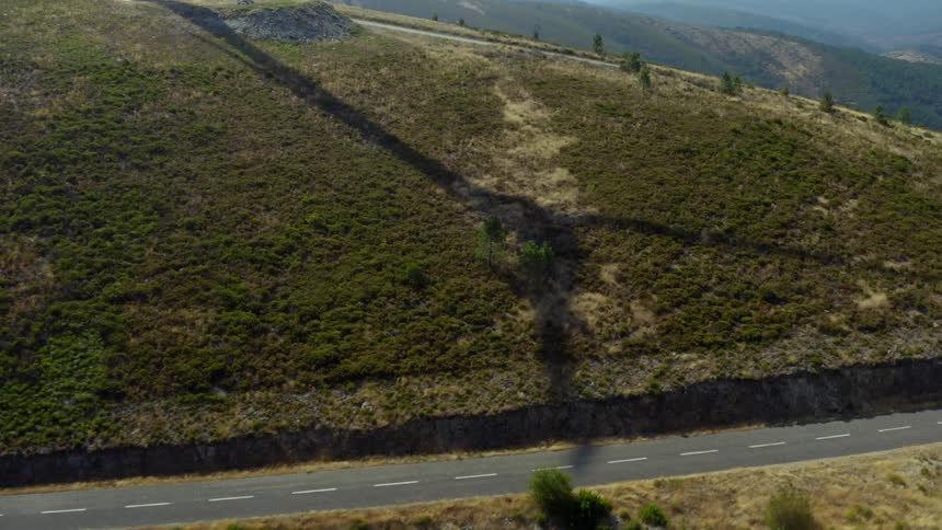 Aerial view of wind turbines shadow reflecting on hillside