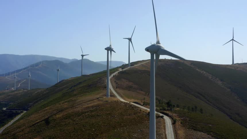 Aerial view of wind turbines spinning over the mountains