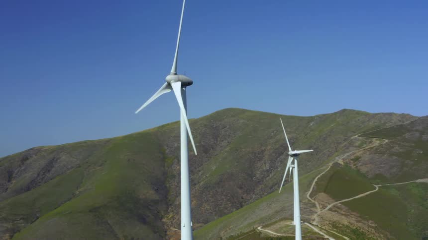 Aerial view of wind turbines on wind farm against the blue sky