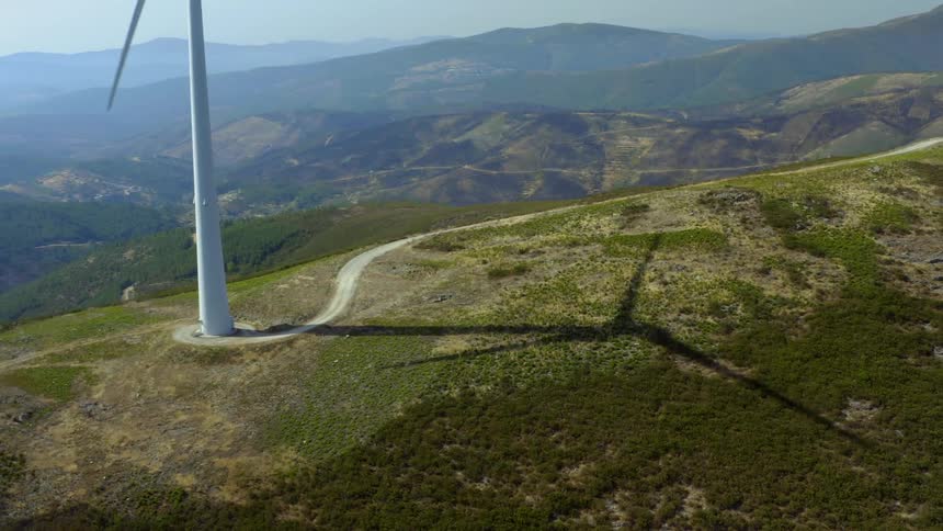 Windmills are spinning on top of a mountain
