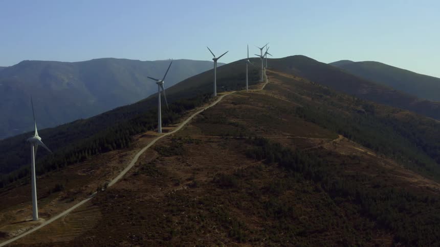 Aerial view of wind turbines spinning on the mountain at morning