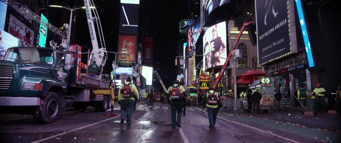Sanitation workers are walking down a city street