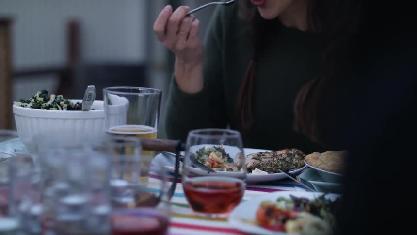 A group of people sit with food in front of them eating