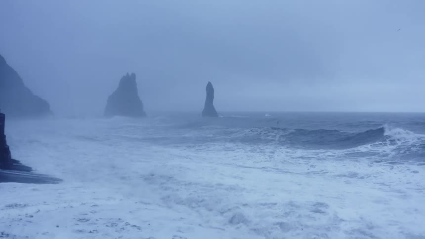 Large choppy waves roll onto the beach during a storm