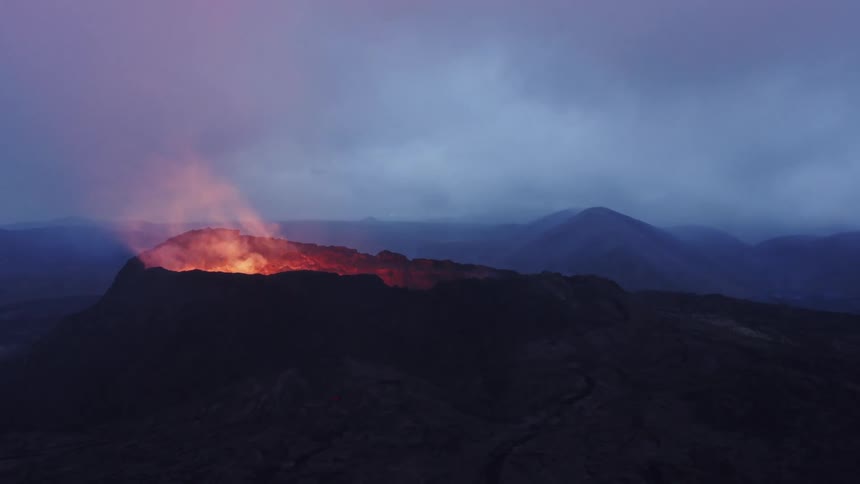 A volcano with molten lava and smoke with the sky and clouds in the background