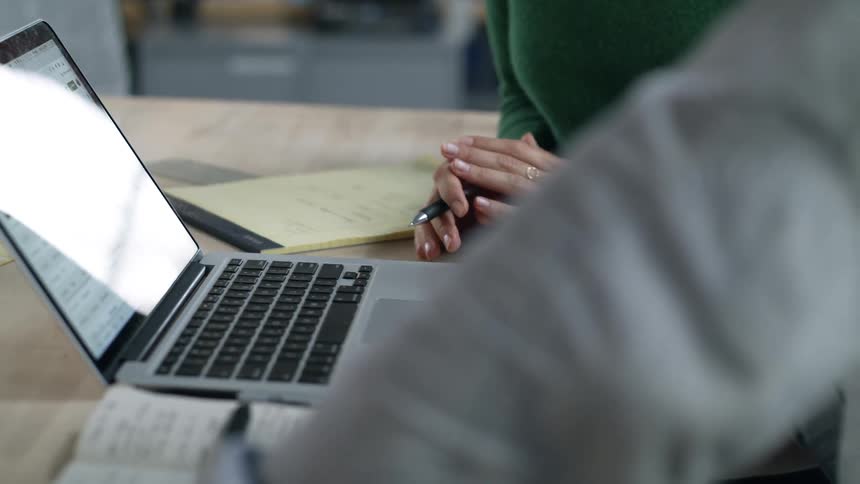 Woman and man discuss contents on laptop display