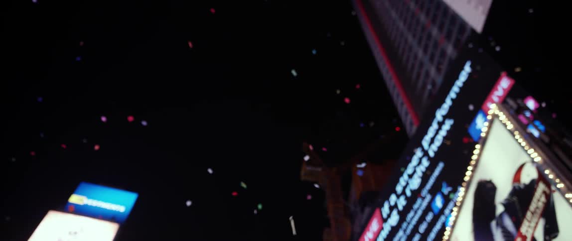 Ticker tape falls at night in a city