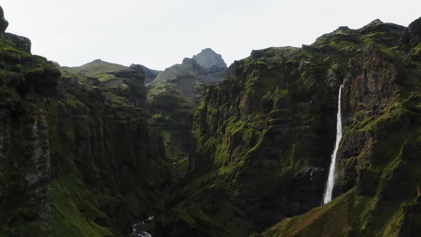 Aerial view of a waterfal flowing from a cliff on a gorge or ravine
