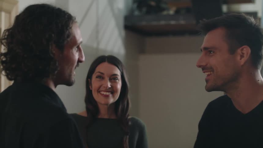 People are standing in a house talking and smiling