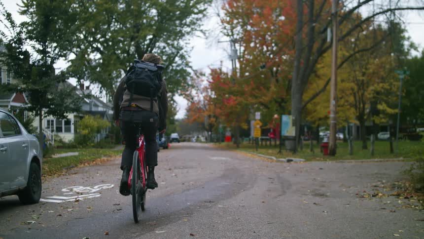 A man rides his bike and makes a turn on the road