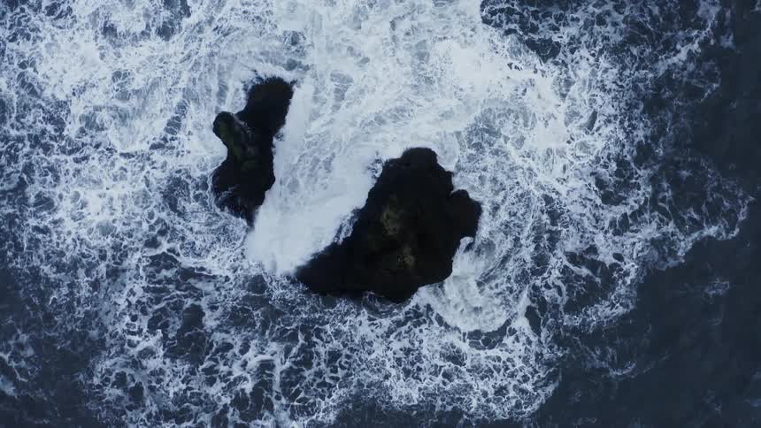 Waves crash against the rocks in the ocean