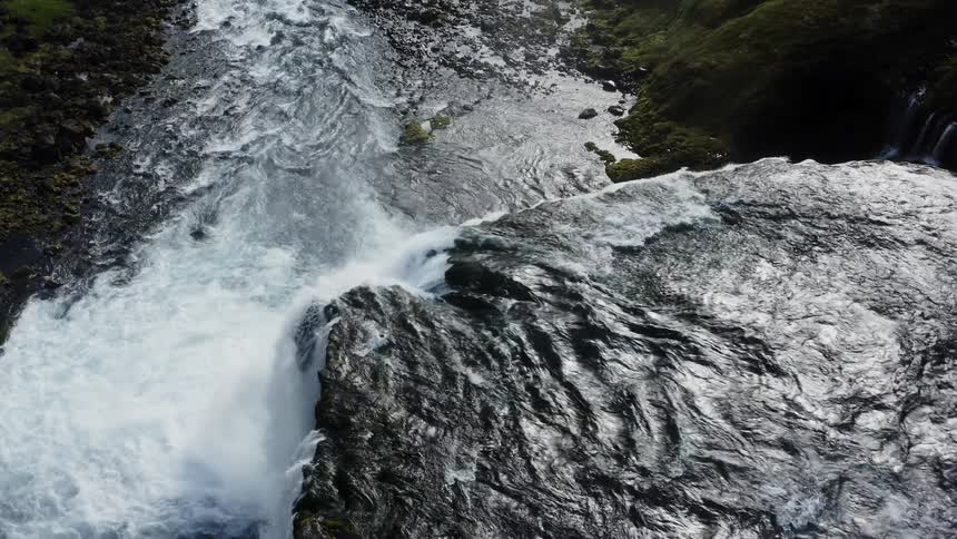 A waterfall crashing in to a river below