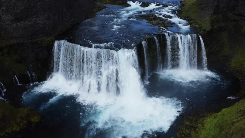 Waterfalls flow as they splash and foam rolling down the river and over rocks