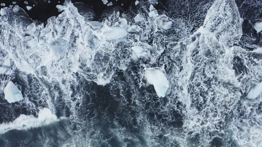 Waves move across an ocean among chunks of ice