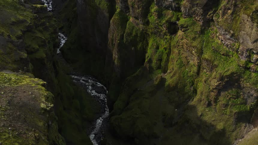 Aerial view of stream flowing through deep valley