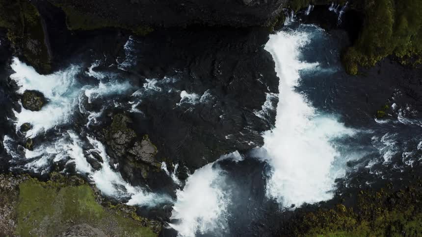 Top down aerial view of a river flowing over the rocksforming a waterfall