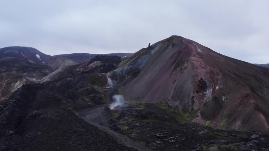 A person is standing on the top of the mountain