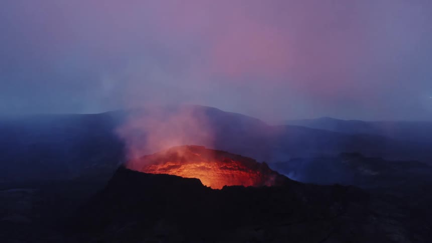 A volcano with molten lava and smoke with the sky and clouds in the background