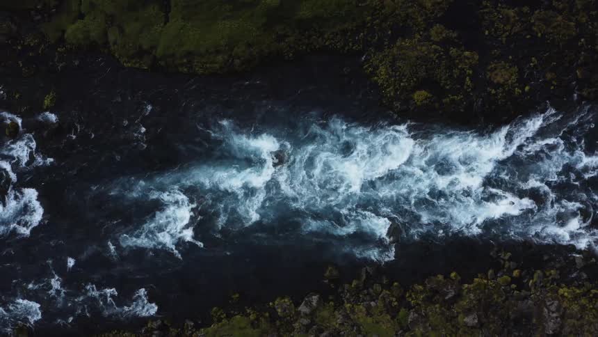 Aerial view of small stream flowing through land